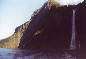 Waterfall in Milford Sound (note two deck cruise ship in lower right corner).
